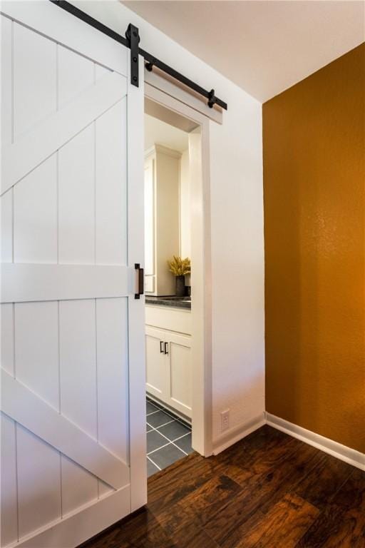 interior space with a barn door and dark hardwood / wood-style flooring