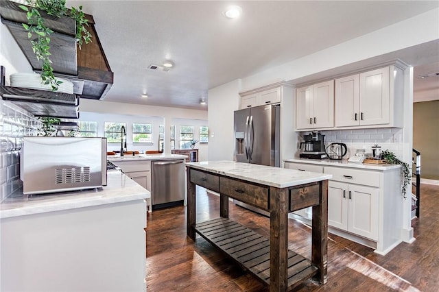 kitchen featuring sink, stainless steel appliances, tasteful backsplash, dark hardwood / wood-style flooring, and white cabinets