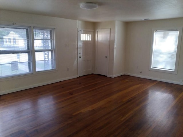 entrance foyer featuring wood finished floors, a healthy amount of sunlight, and baseboards