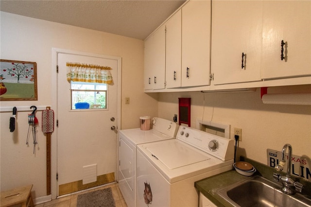 laundry area featuring cabinets, washing machine and dryer, and sink