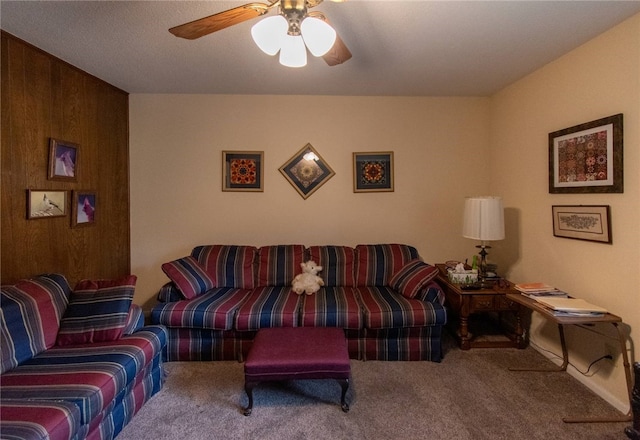 living room featuring ceiling fan, carpet floors, and wooden walls