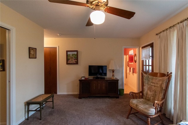 living area with carpet and ceiling fan