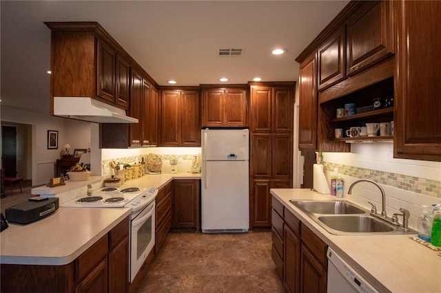 kitchen featuring tasteful backsplash, sink, and white appliances