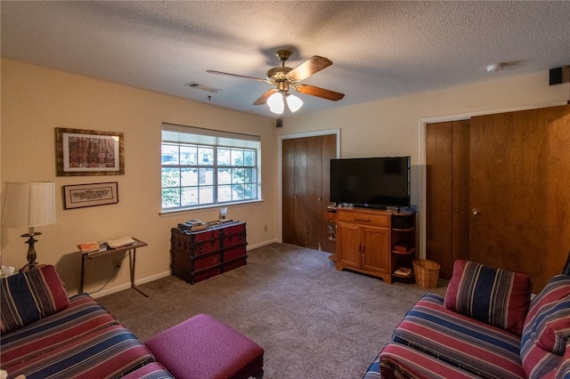 carpeted living room featuring a textured ceiling and ceiling fan