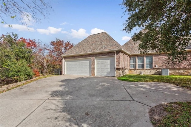 view of front of house with central AC and a garage