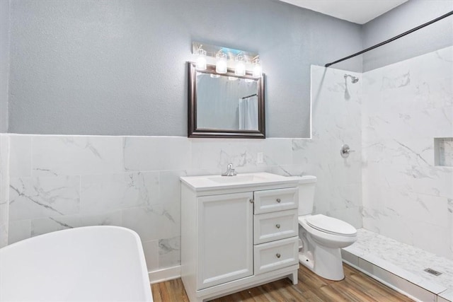 full bathroom with wood-type flooring, independent shower and bath, vanity, and tile walls