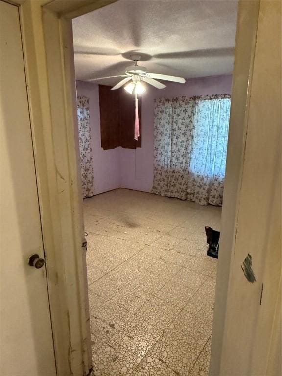 spare room featuring ceiling fan and a textured ceiling