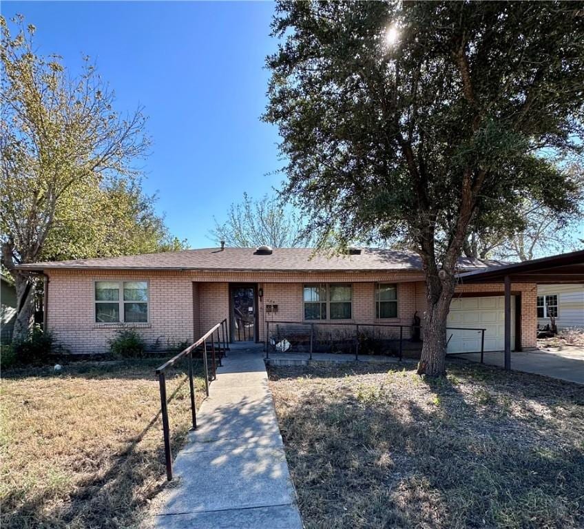 ranch-style house with a garage and a front lawn