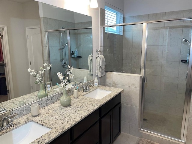 bathroom featuring a shower with door and vanity