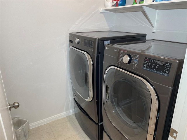 laundry room featuring washing machine and clothes dryer and light tile patterned flooring