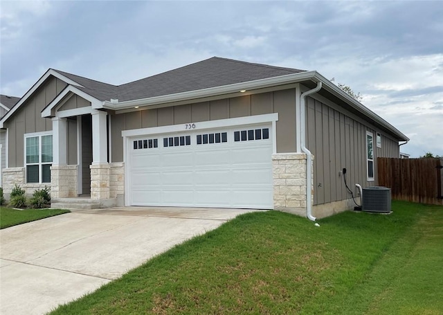 view of front facade with a front lawn, central AC unit, and a garage