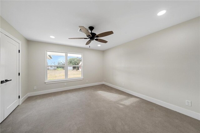 carpeted spare room with ceiling fan