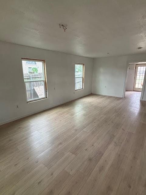 empty room with baseboards and light wood-style floors