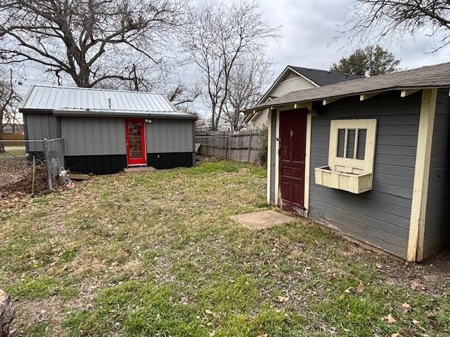 view of yard with a storage shed, an outdoor structure, and fence