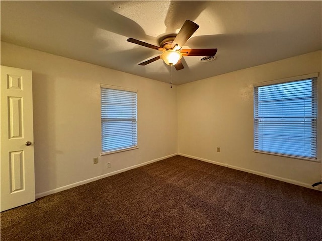 carpeted spare room featuring ceiling fan