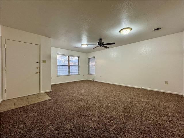 empty room featuring ceiling fan, carpet floors, and a textured ceiling