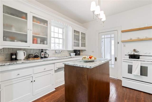 kitchen featuring electric range, dark hardwood / wood-style floors, pendant lighting, and a wealth of natural light