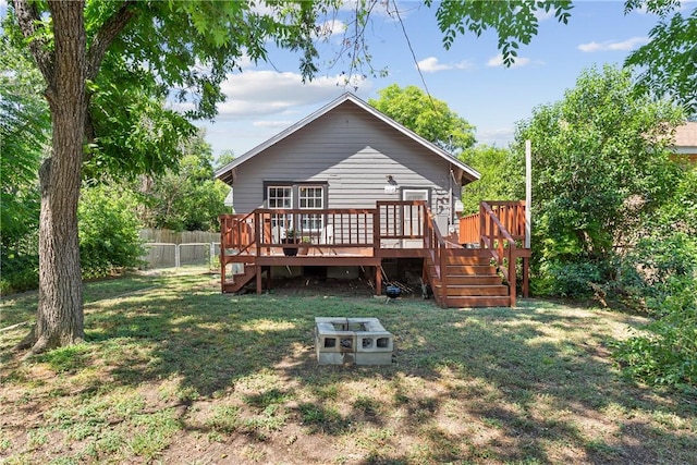 rear view of property with a deck and a yard