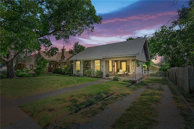 view of front of property with a porch and a yard