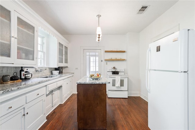 kitchen with white appliances, dark wood-type flooring, white cabinets, sink, and hanging light fixtures