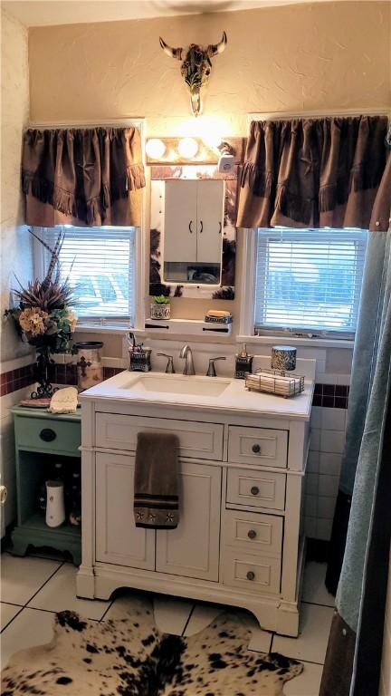 bathroom with vanity, tile patterned floors, and tile walls