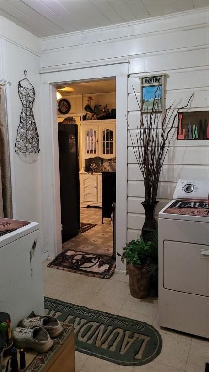 laundry room featuring crown molding, light tile patterned flooring, and washer / dryer