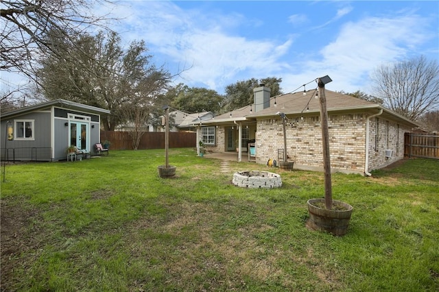 view of yard featuring an outdoor structure and a fire pit