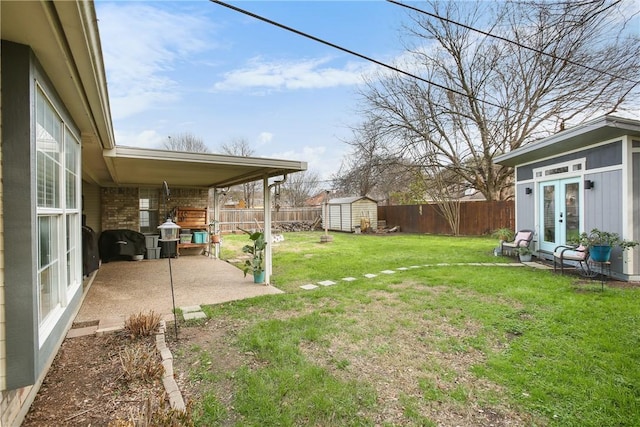 view of yard featuring a shed, a patio area, and french doors