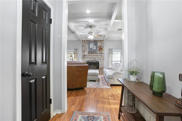 corridor featuring beamed ceiling, wood-type flooring, and coffered ceiling