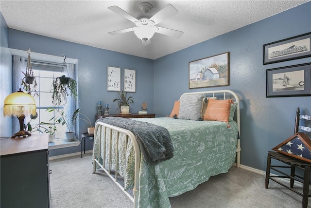 carpeted bedroom featuring a textured ceiling and ceiling fan