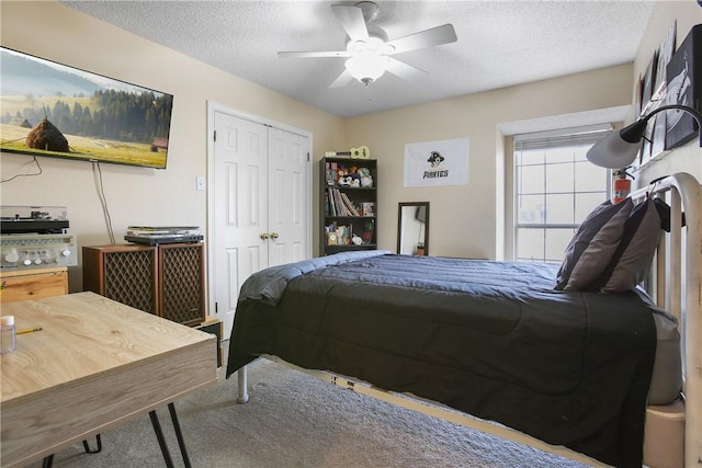 bedroom with a textured ceiling, ceiling fan, and a closet