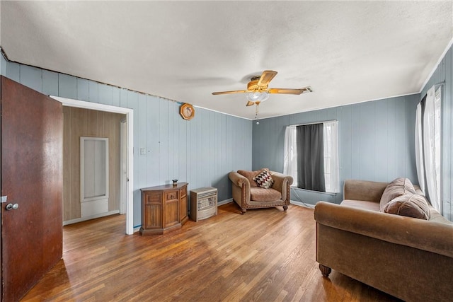 living area with ceiling fan and wood finished floors