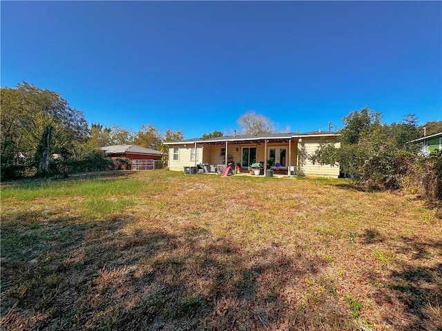 rear view of property featuring a lawn