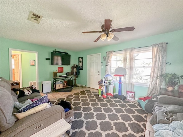 interior space with tile patterned floors, ceiling fan, and a textured ceiling