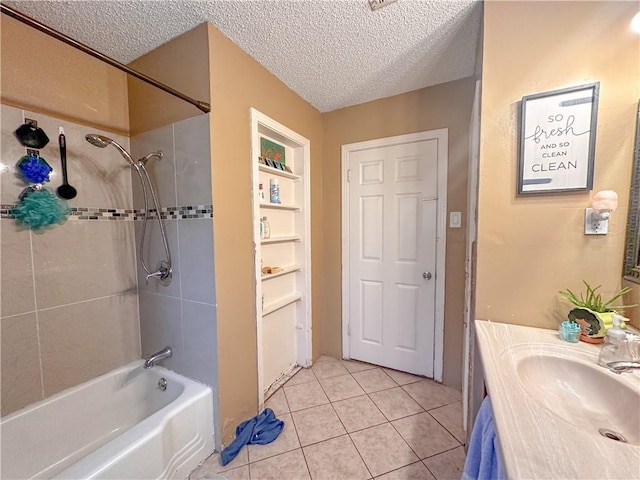 bathroom featuring tile patterned floors, tiled shower / bath combo, a textured ceiling, and vanity