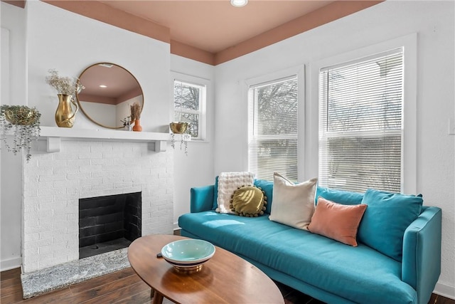 living room featuring a fireplace, wood finished floors, and baseboards