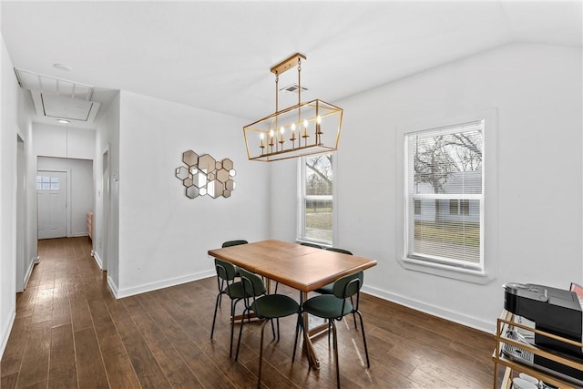 dining room with attic access, lofted ceiling, dark wood-type flooring, and baseboards