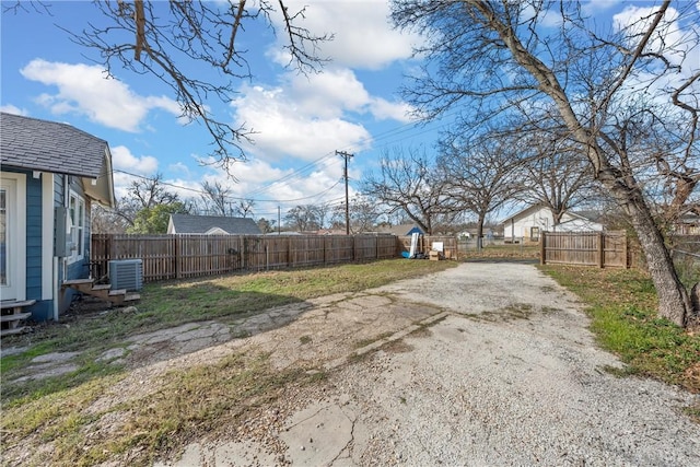 view of yard featuring central AC and fence private yard