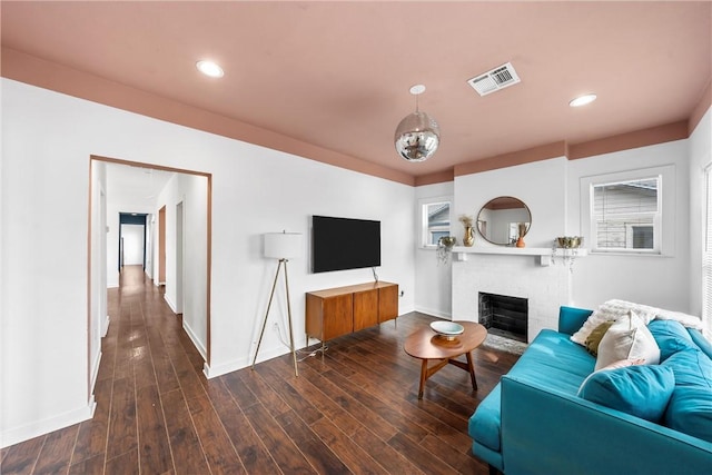 living room with recessed lighting, visible vents, a brick fireplace, wood finished floors, and baseboards