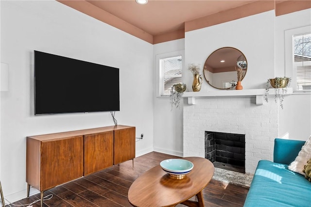 living room with a brick fireplace, baseboards, wood finished floors, and recessed lighting