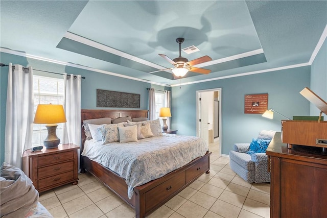 tiled bedroom with crown molding, ceiling fan, and a raised ceiling