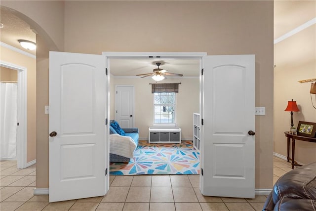 tiled bedroom with ceiling fan and ornamental molding