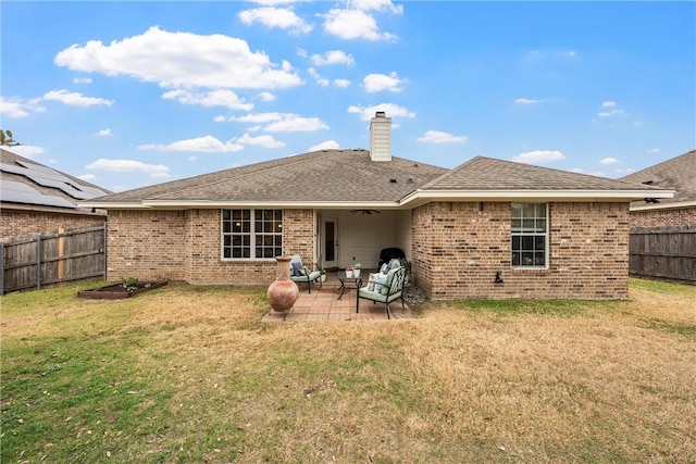 back of property with a yard and a patio