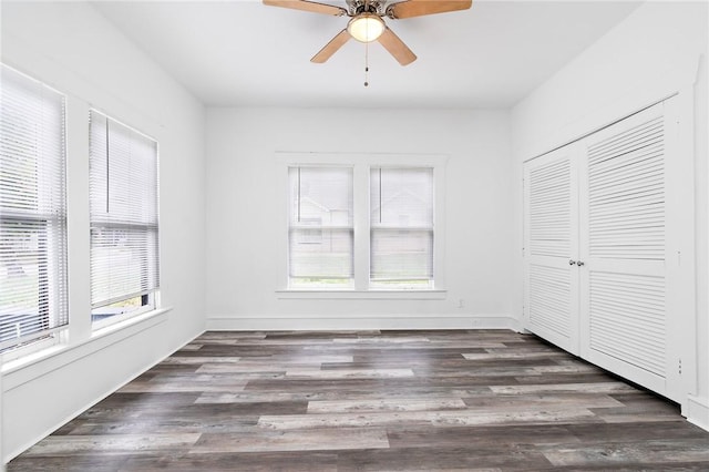 unfurnished bedroom with dark hardwood / wood-style flooring, a closet, and ceiling fan