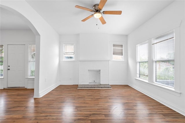 unfurnished living room featuring dark hardwood / wood-style floors, ceiling fan, and a fireplace