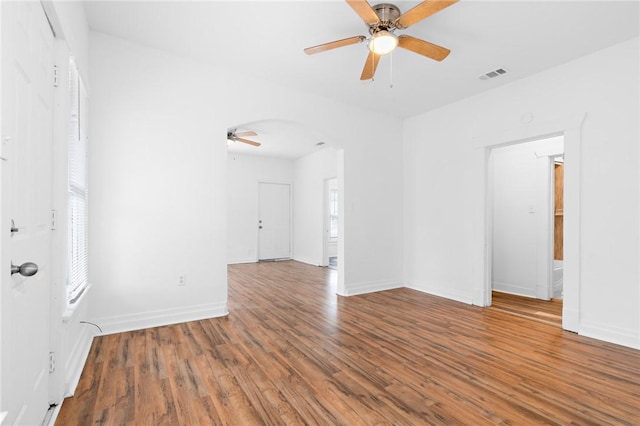 spare room featuring wood-type flooring, a wealth of natural light, and ceiling fan