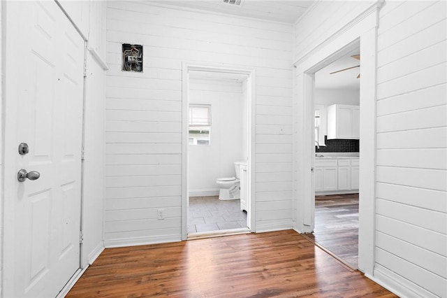 hall with wood walls and wood-type flooring