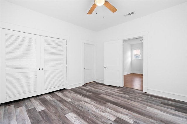 unfurnished bedroom featuring dark hardwood / wood-style flooring, a closet, and ceiling fan