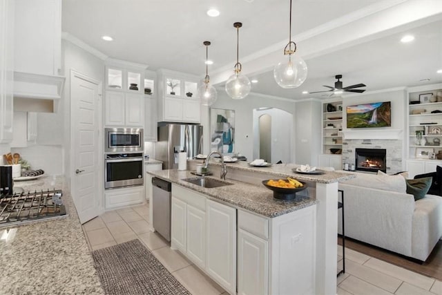 kitchen with white cabinets, appliances with stainless steel finishes, decorative light fixtures, and sink