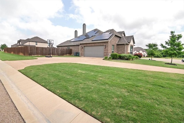 view of front of house featuring central AC, solar panels, a garage, and a front lawn